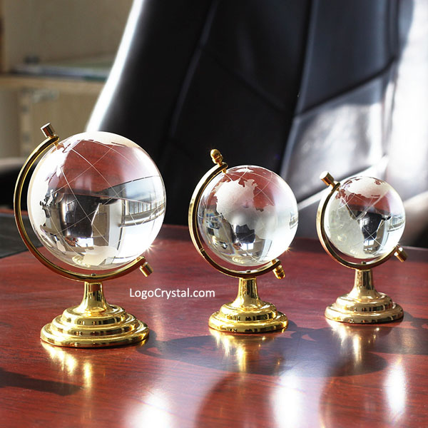 El globo de cristal con metal de color dorado de pie sobre la mesa, un regalo corporativo perfecto para los negocios.
